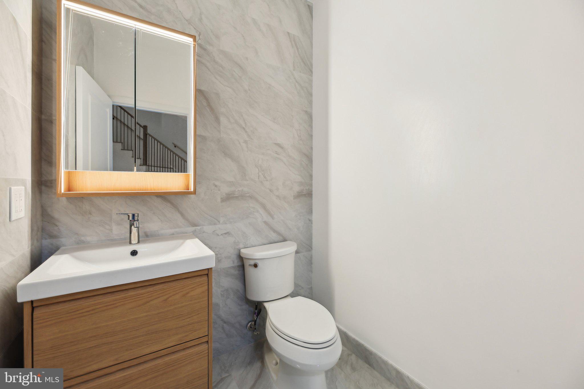 8325 Grove Angle Road Ellicott City, MD 21043 - Photo 21 of 57 a bathroom with a toilet sink and mirror