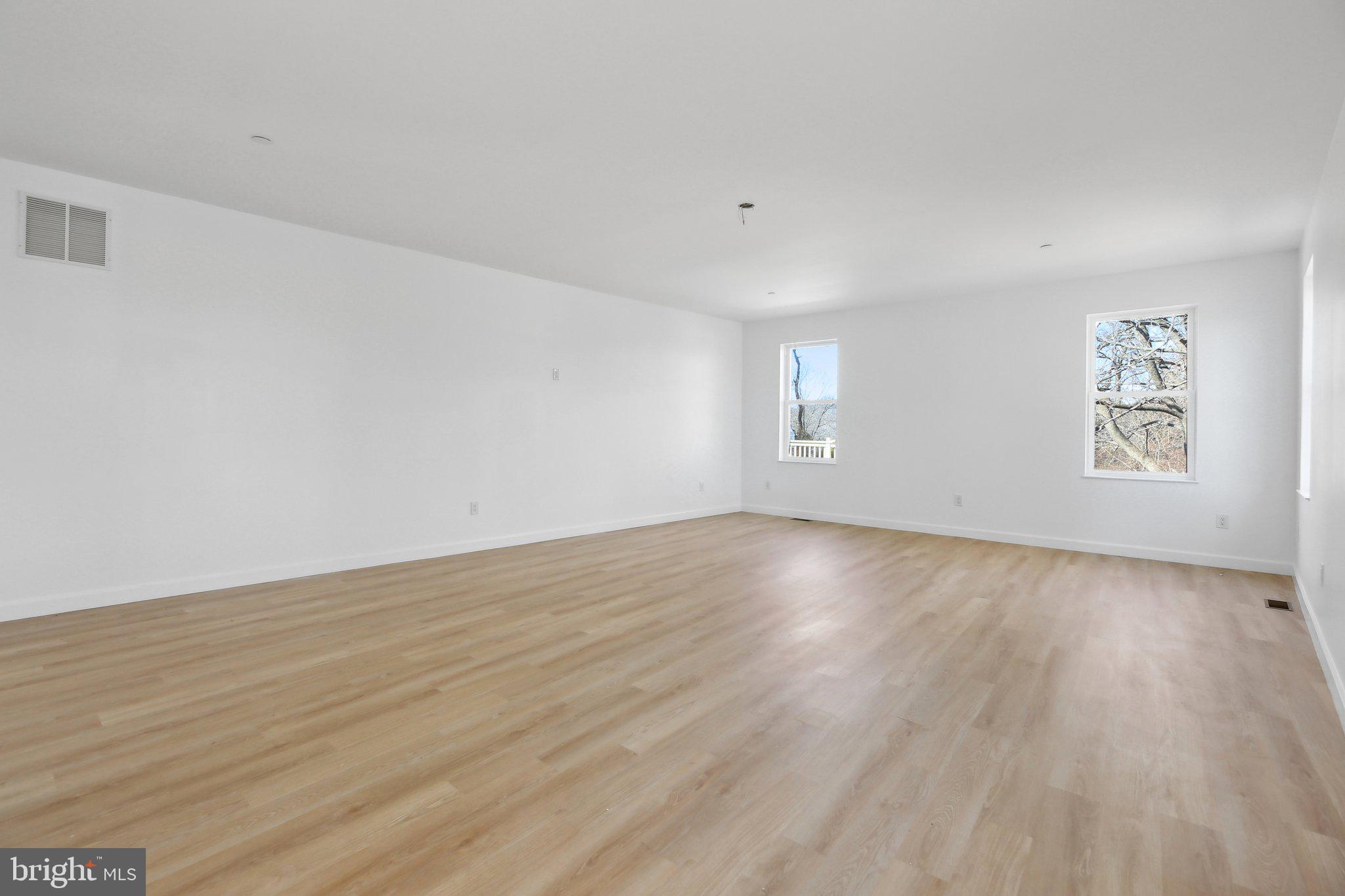 8325 Grove Angle Road Ellicott City, MD 21043 - Photo 23 of 57 an empty room with wooden floor and windows