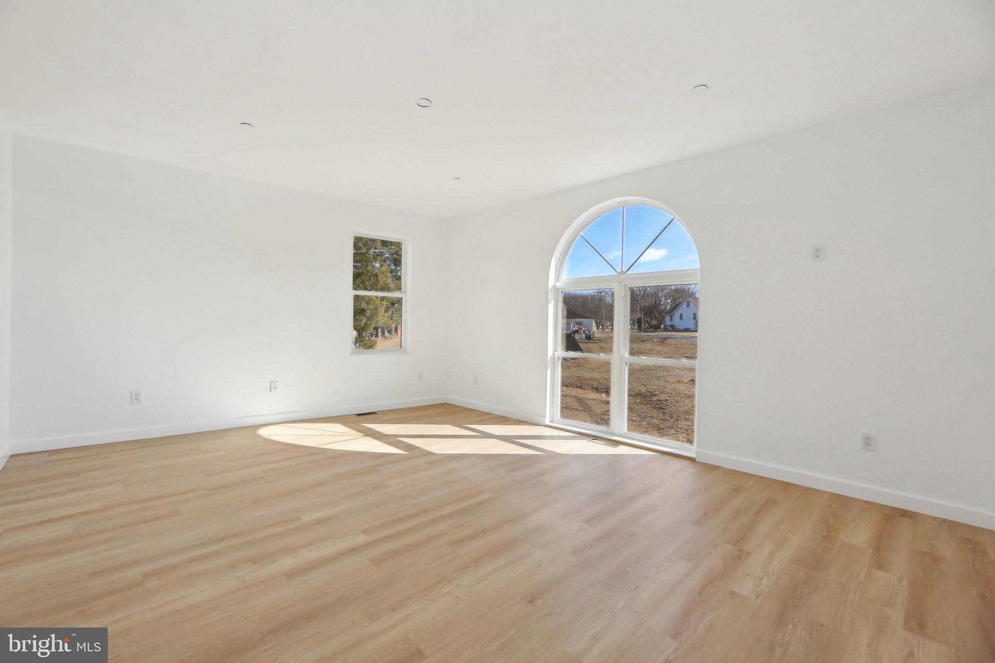 8325 Grove Angle Road Ellicott City, MD 21043 - Photo 27 of 57 an empty room with wooden floor and windows