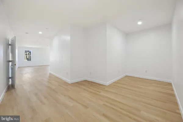 an empty room with wooden floor and a window