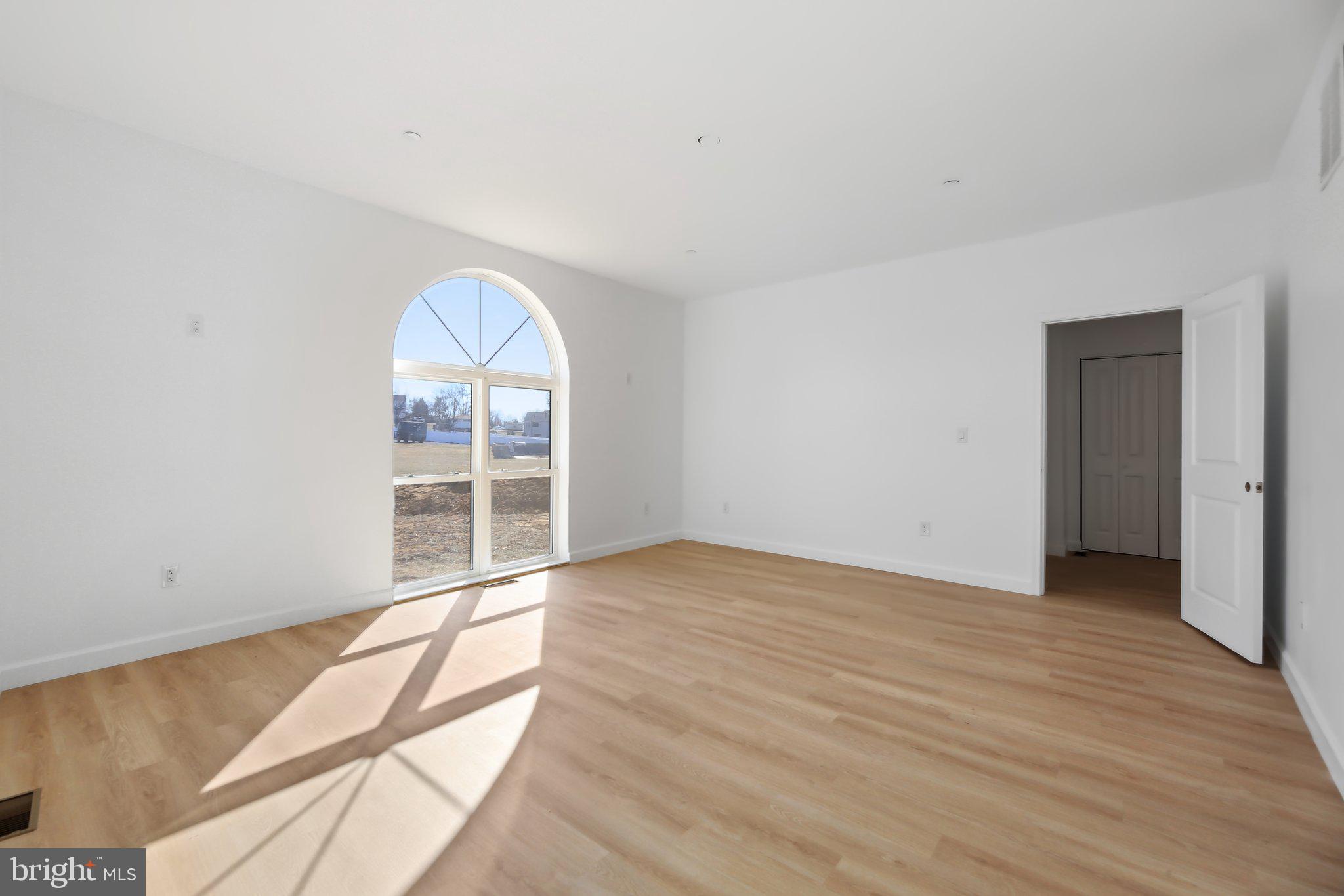 8325 Grove Angle Road Ellicott City, MD 21043 - Photo 28 of 57 a view of an empty room with wooden floor and a window