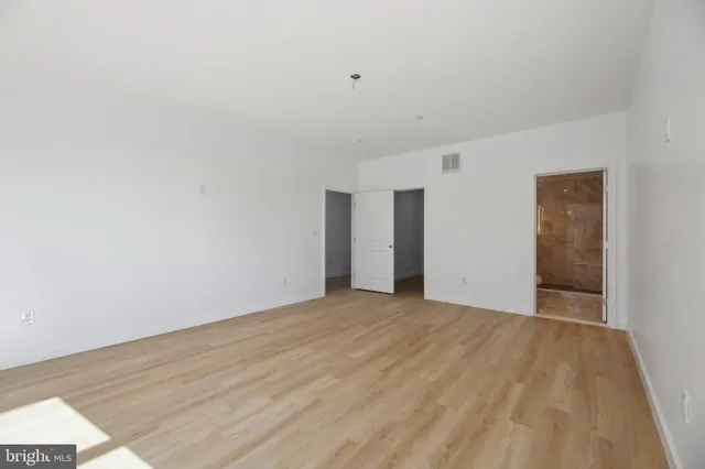 a view of an empty room with wooden floor