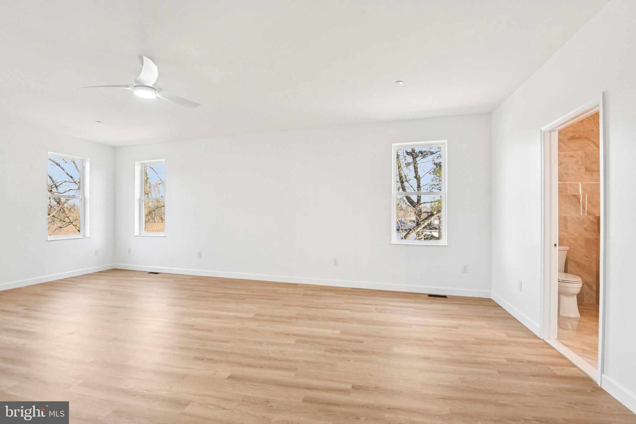 8325 Grove Angle Road Ellicott City, MD 21043 - Photo 32 of 72 an empty room with wooden floor and windows