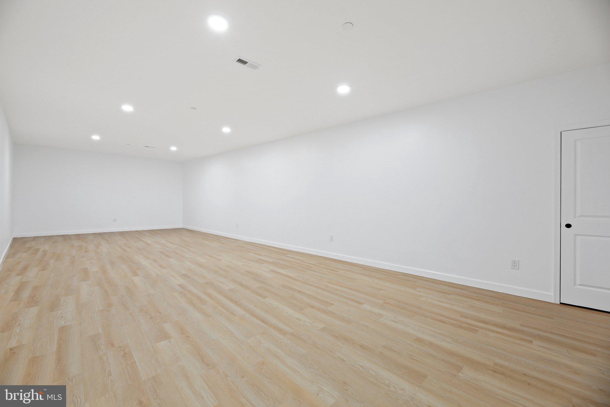 8325 Grove Angle Road Ellicott City, MD 21043 - Photo 35 of 57 an empty room with wooden floor and windows