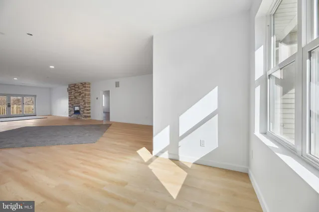 a view of empty room with wooden floor and fireplace