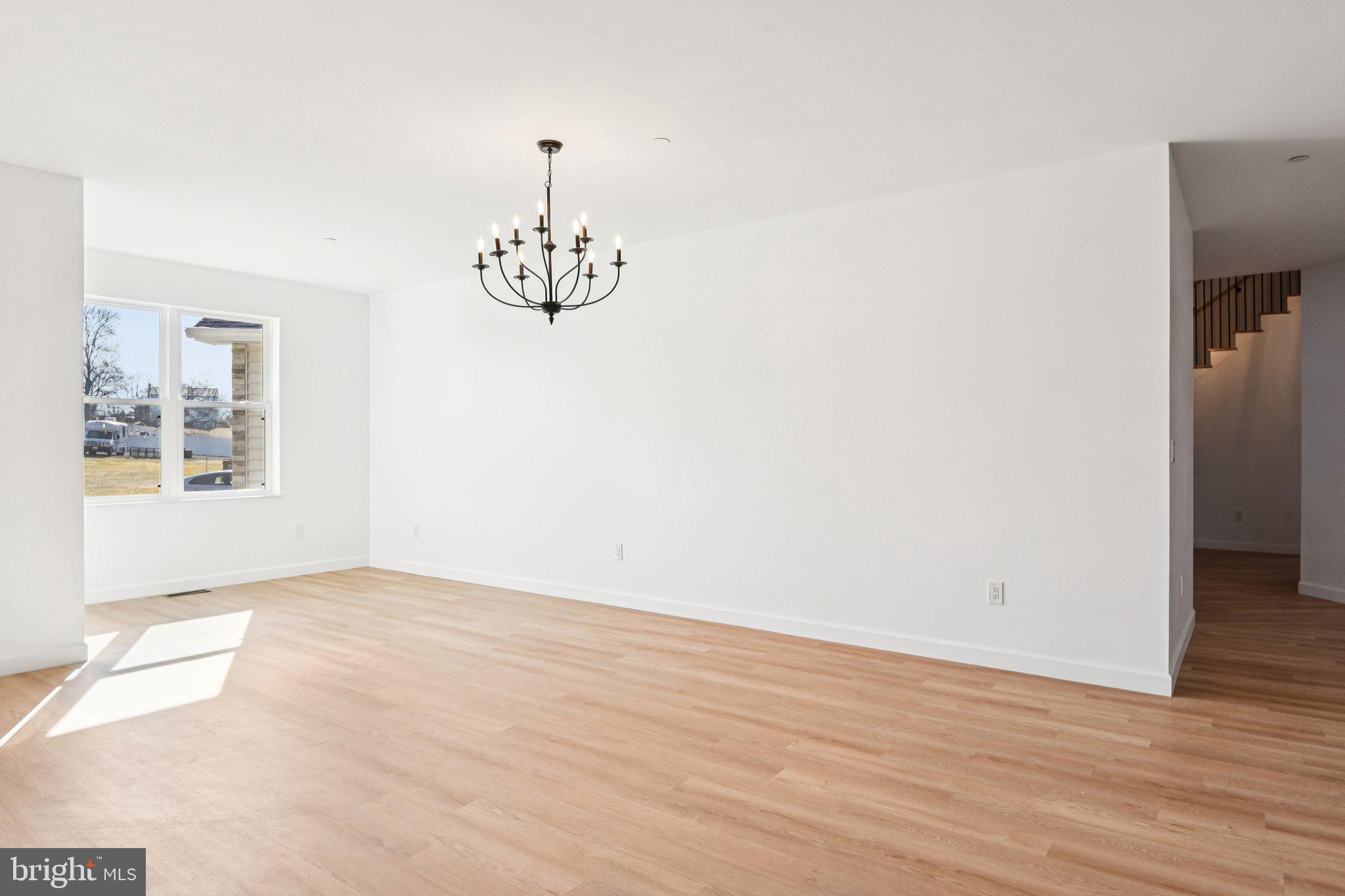 8325 Grove Angle Road Ellicott City, MD 21043 - Photo 7 of 72 an empty room with wooden floor and windows