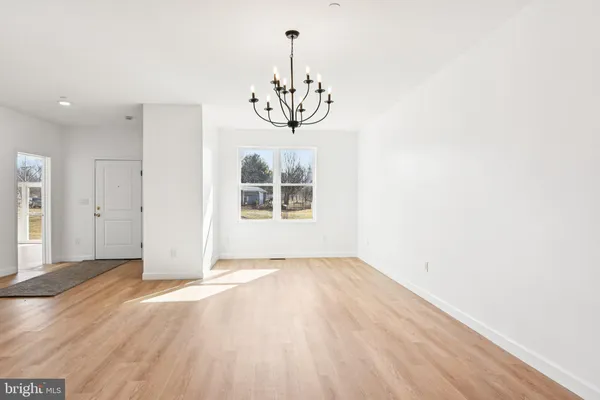 a view of a room with wooden floor chandelier closet and windows