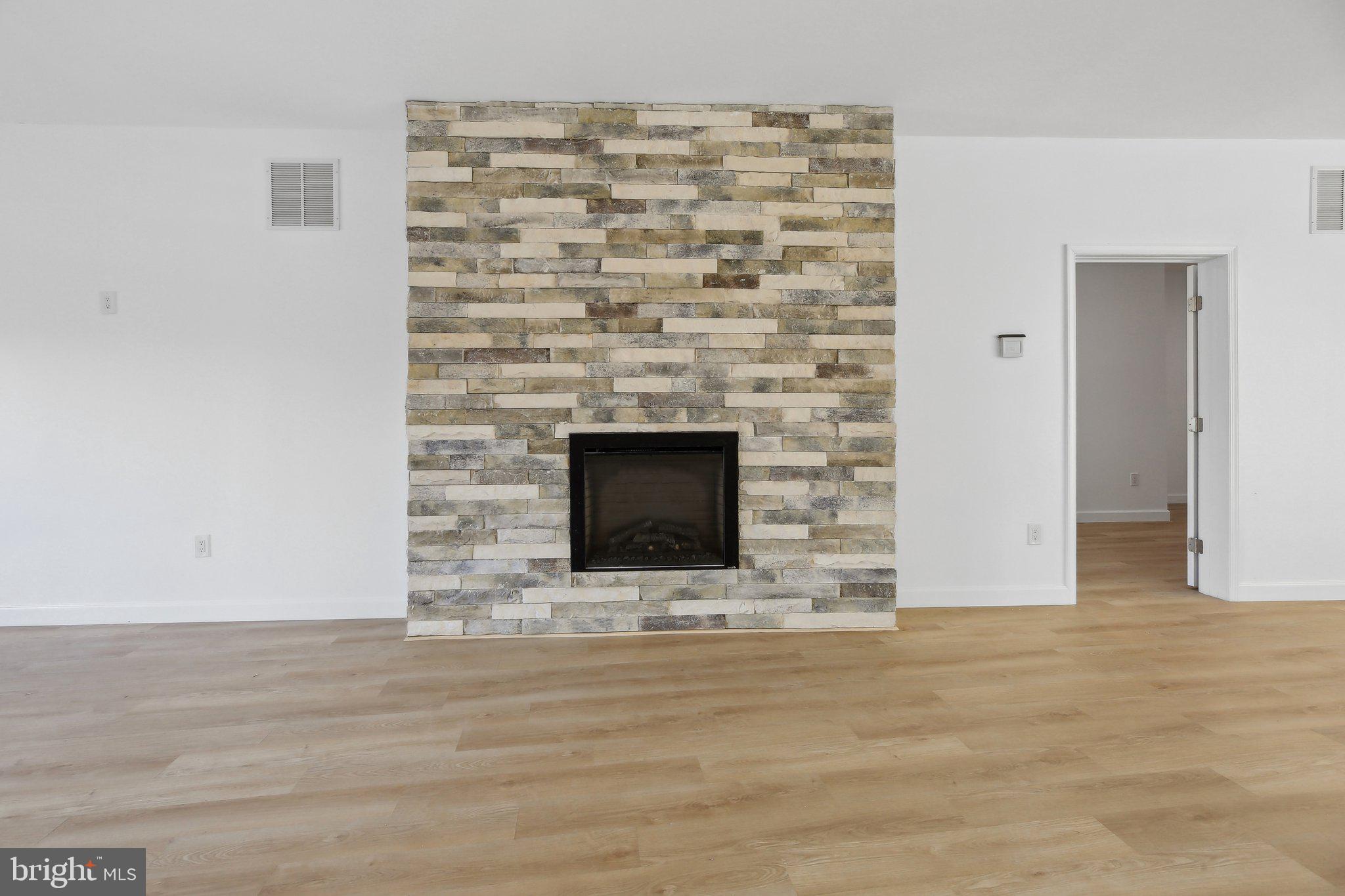 8325 Grove Angle Road Ellicott City, MD 21043 - Photo 9 of 57 a view of empty room with wooden floor and fireplace