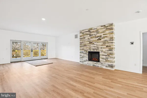 a view of an empty room with a fireplace and a window