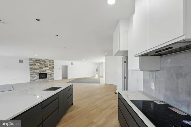 a large kitchen with a large counter top stainless steel appliances and cabinets