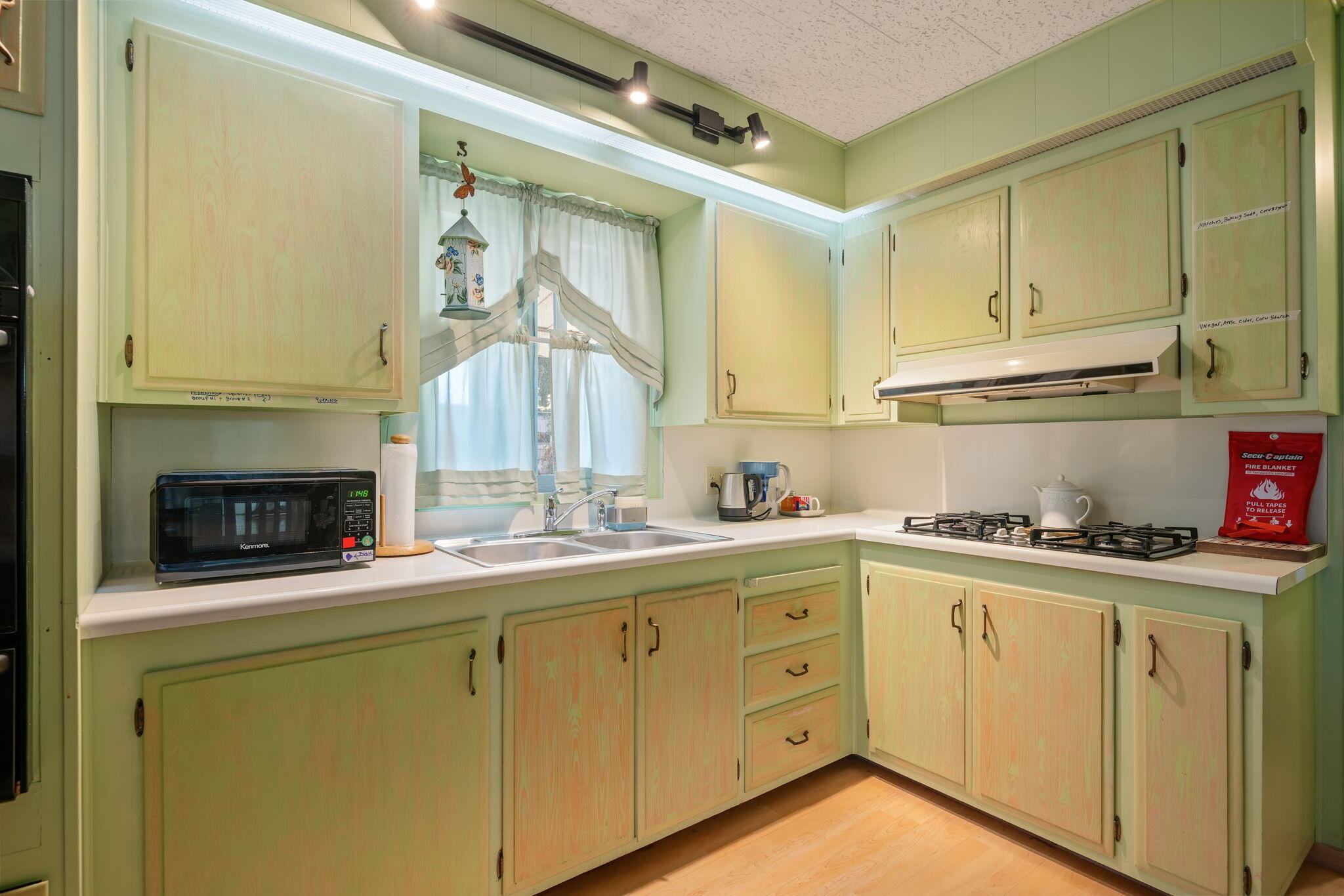 333 Old Mill Road, Unit 317 Santa Barbara, CA 93110 - Photo 7 of 12 a kitchen with white cabinets and white appliances