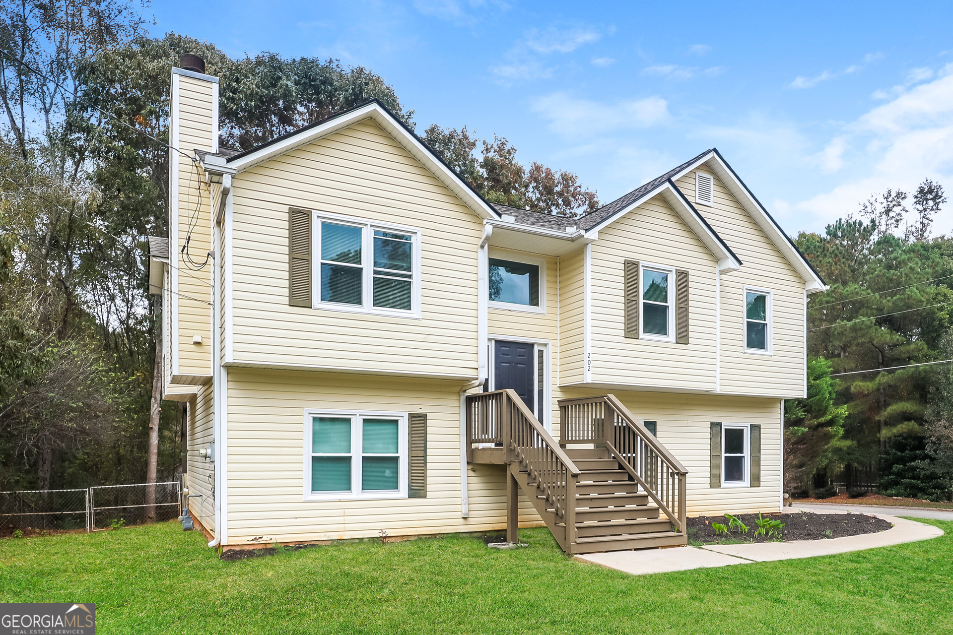 202 Wesley Mill Way Villa Rica, GA 30180 - Photo 2 of 17 a front view of a house with a garden