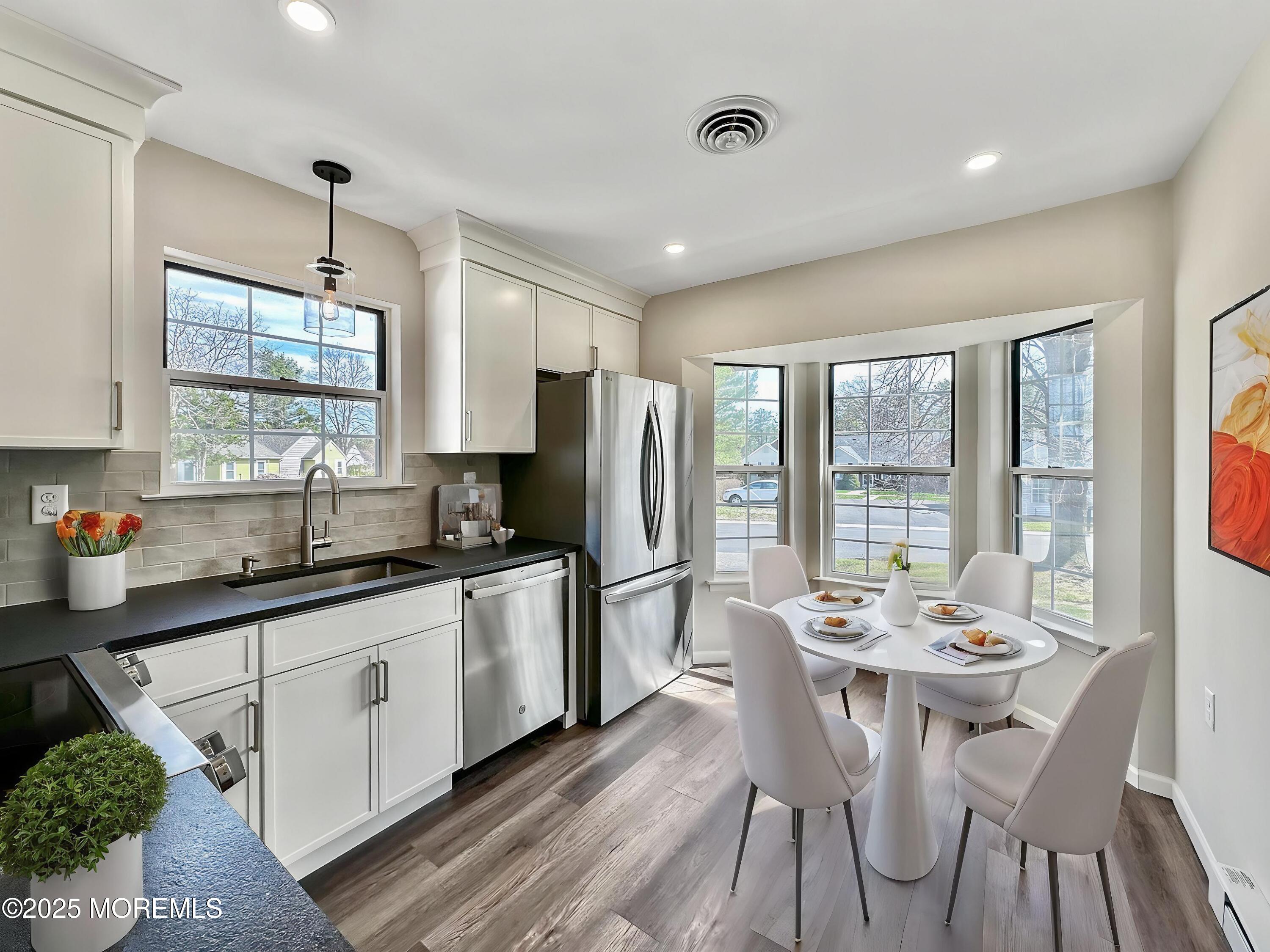 15D Alpine Road, Unit C Whiting, NJ 08759 - Photo 3 of 36 a kitchen with stainless steel appliances granite countertop a stove top oven a sink dishwasher a dining table and chairs with wooden floor