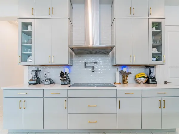 a kitchen with a sink dishwasher and a clock on the wall