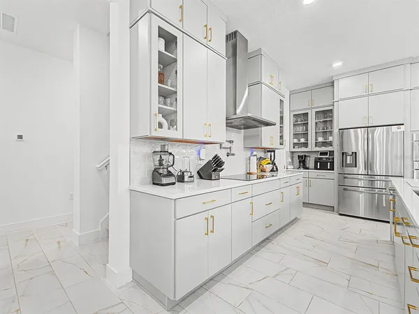 a kitchen with white cabinets and sink