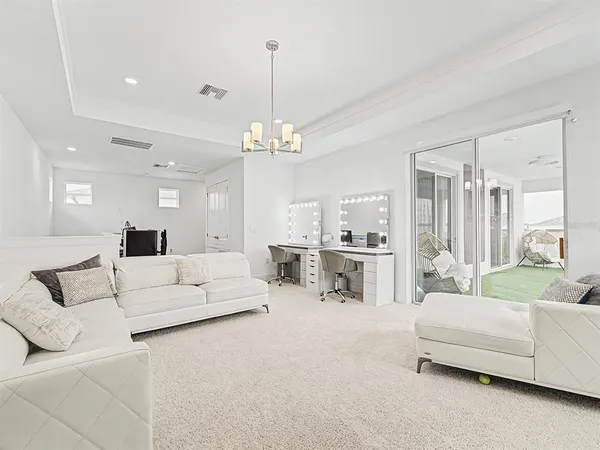 a view of a patio with couches chairs and floor to ceiling window and potted plants