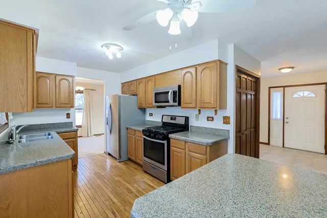 a kitchen with stainless steel appliances granite countertop a sink stove and refrigerator