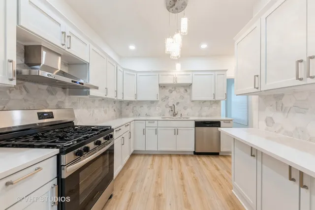 a kitchen with granite countertop stainless steel appliances a sink stove top oven and cabinets