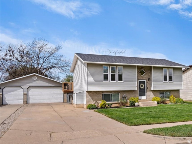 Undisclosed Address Roy, UT 84067 - Photo 1 of 1 Split foyer home with a detached garage, an outdoor structure, a front yard, and brick siding