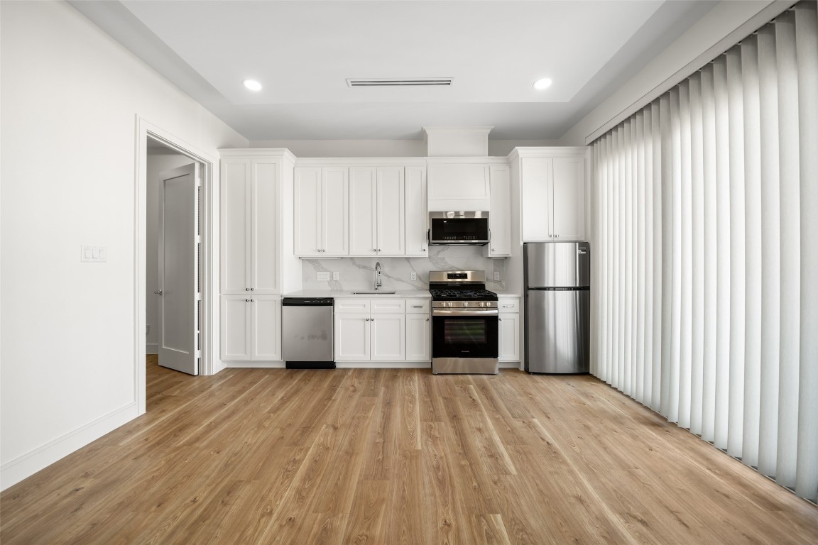 1839 Colquitt Street Houston, TX 77098 - Photo 16 of 19 a kitchen with white cabinets and stainless steel appliances