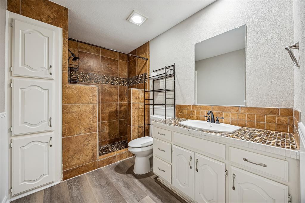 116 Timberview Court Burleson, TX 76028 - Photo 18 of 37 a bathroom with a granite countertop sink toilet and shower