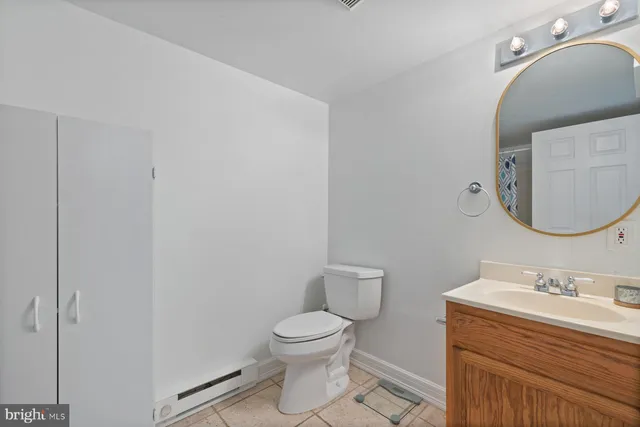 a bathroom with a granite countertop toilet a sink and a mirror