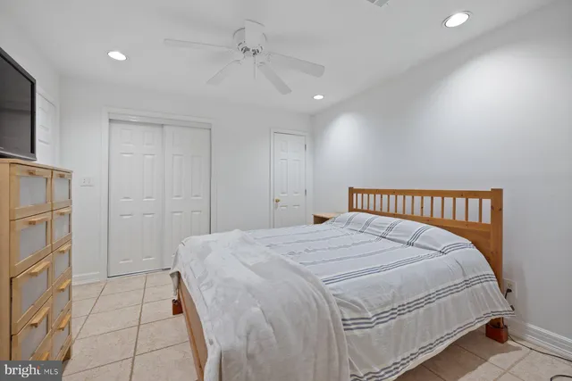 a bedroom with a bed and a refrigerator