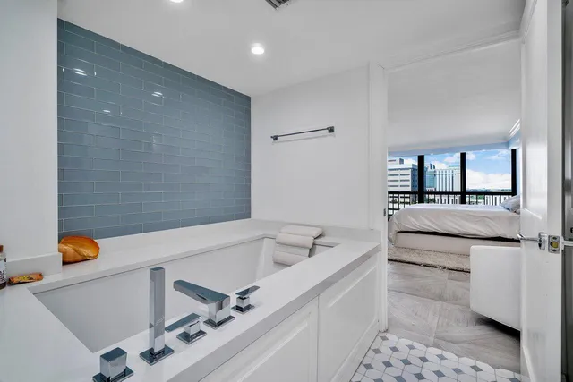 a spacious bedroom with a bed and a flat screen tv