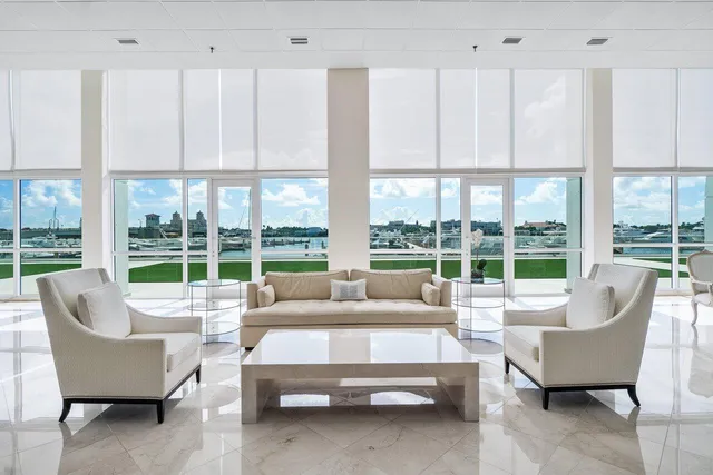 a living room with furniture large windows and wooden floor