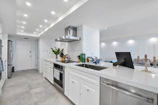 a kitchen with white cabinets and sink