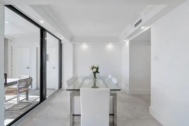 a large white bed sitting in a bedroom next to a lamp