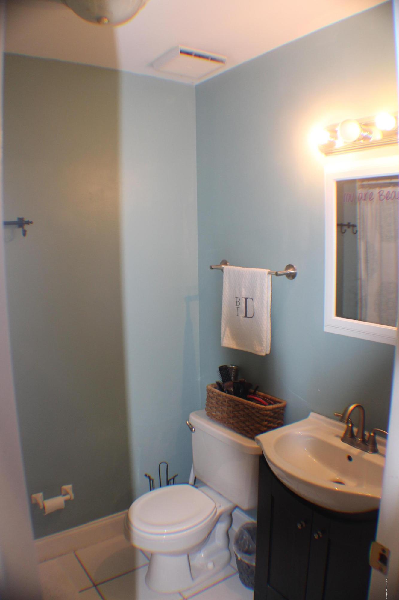 5871 Ridgeway Road East Jacksonville, FL 32244 - Photo 4 of 19 a bathroom with a toilet a sink and mirror