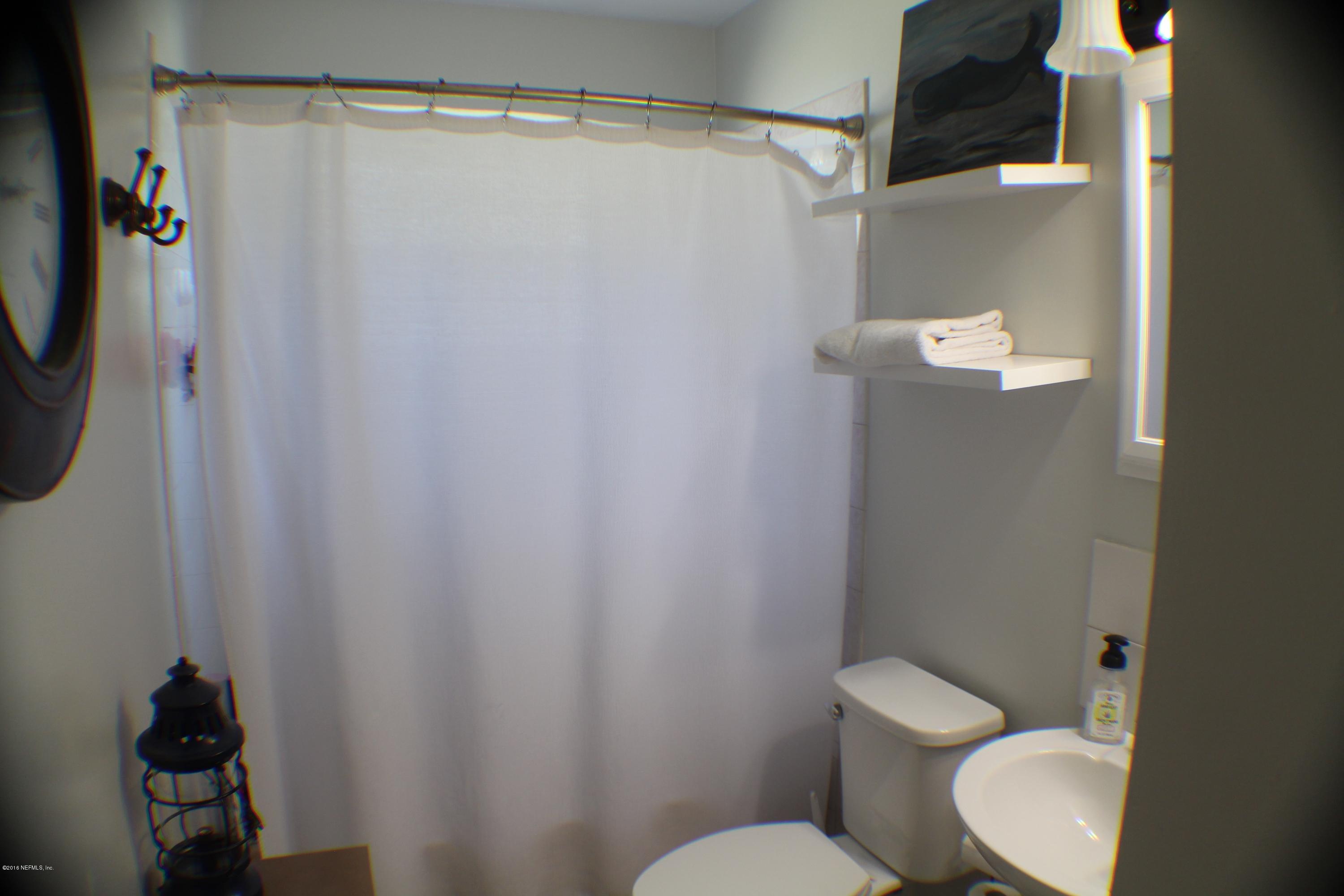 5871 Ridgeway Road East Jacksonville, FL 32244 - Photo 7 of 19 a white toilet sitting next to a shower curtain