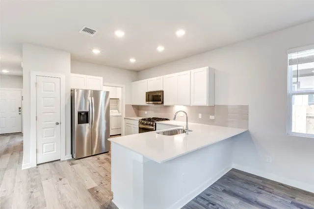 a kitchen with stainless steel appliances a refrigerator sink and microwave