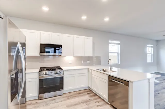 a kitchen with a sink appliances and cabinets