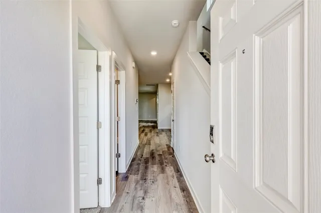 a view of a hallway with wooden floor and staircase