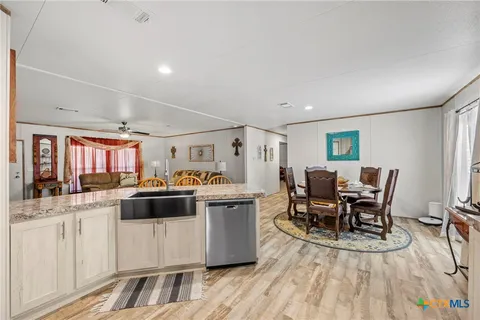 a view of a dining room with furniture a rug and wooden floor