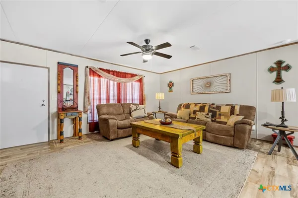 a living room with furniture and a ceiling fan