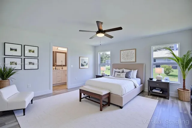 a spacious bedroom with a bed couch and windows