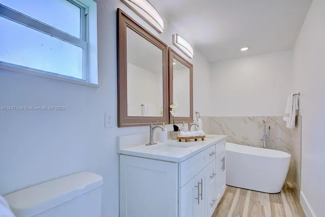 a bathroom with a sink a toilet and mirror