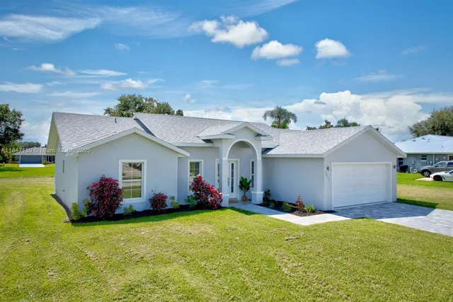 a front view of a house with yard and swimming pool