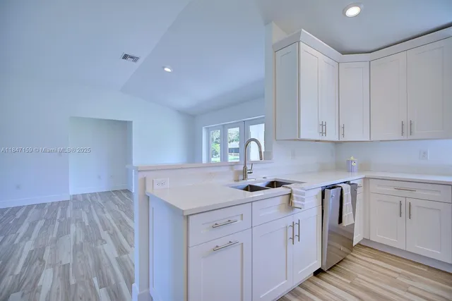 a kitchen with sink cabinets and wooden floor