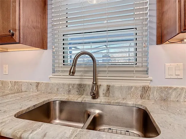 a kitchen with granite countertop stainless steel appliances a refrigerator and cabinets