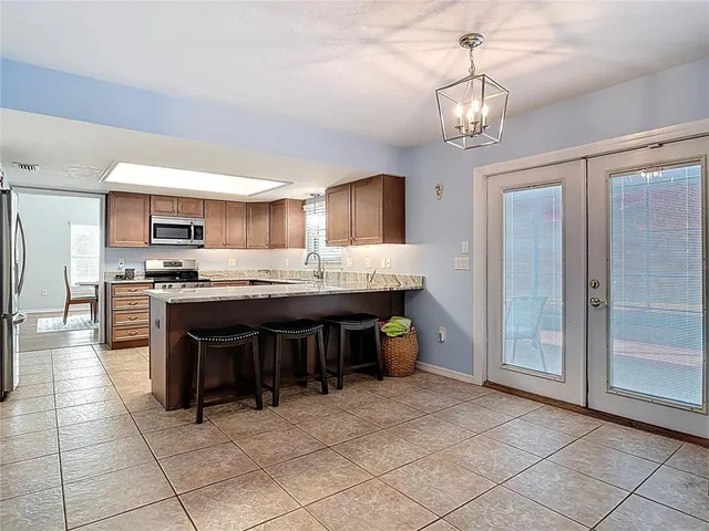 a bedroom with a bed a window and a lamp