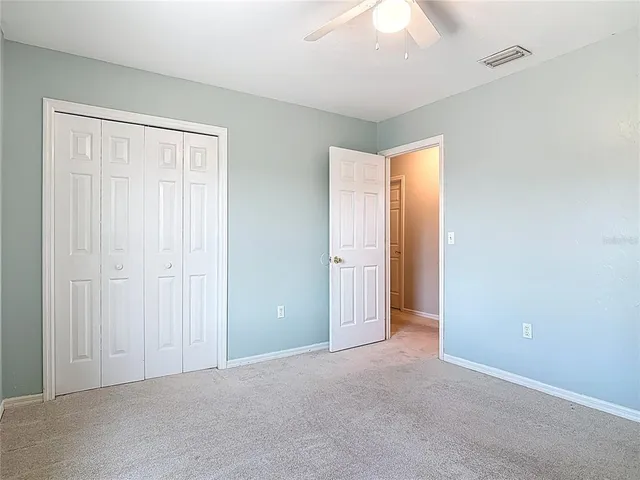 an empty room with a window and a fan