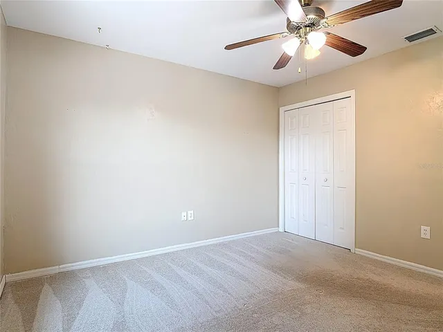 a view of an empty room and chandelier fan