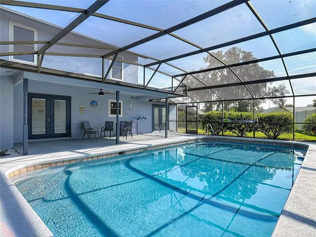 an aerial view of a house with a swimming pool outdoor seating and yard