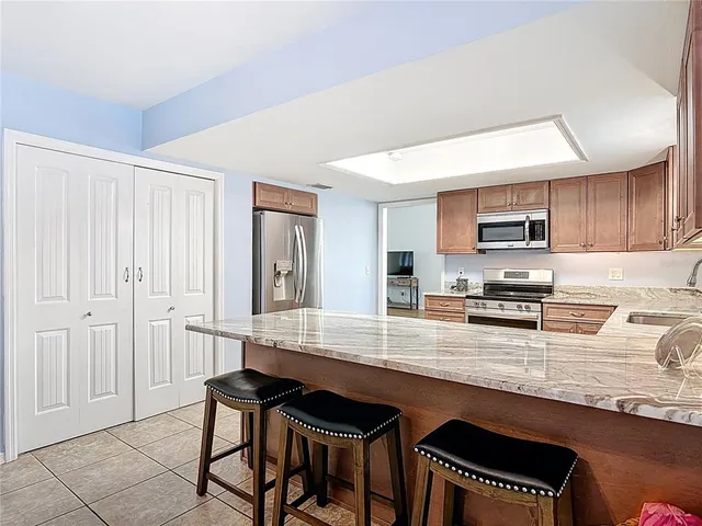 a kitchen with stainless steel appliances granite countertop a stove sink microwave and cabinets