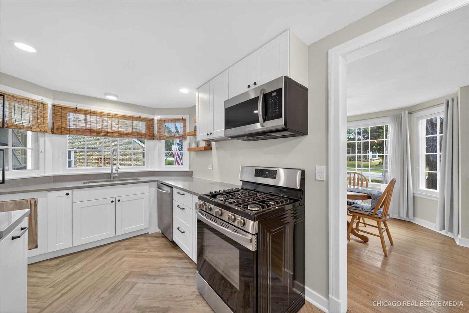 844 Bode Road Elgin, IL 60120 - Photo 10 of 34 a kitchen with stainless steel appliances granite countertop a stove top oven a sink dishwasher a dining table and chairs with wooden floor
