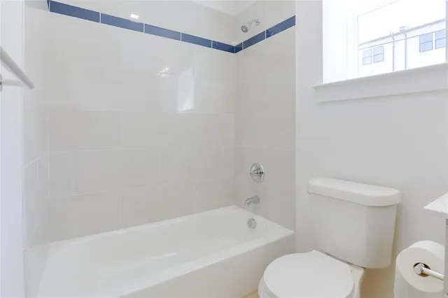 a white toilet sitting next to a bath tub shower